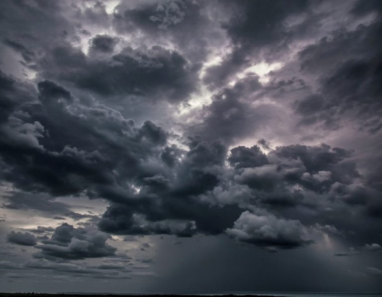 Dark, dramatic storm clouds with hints of light breaking through.