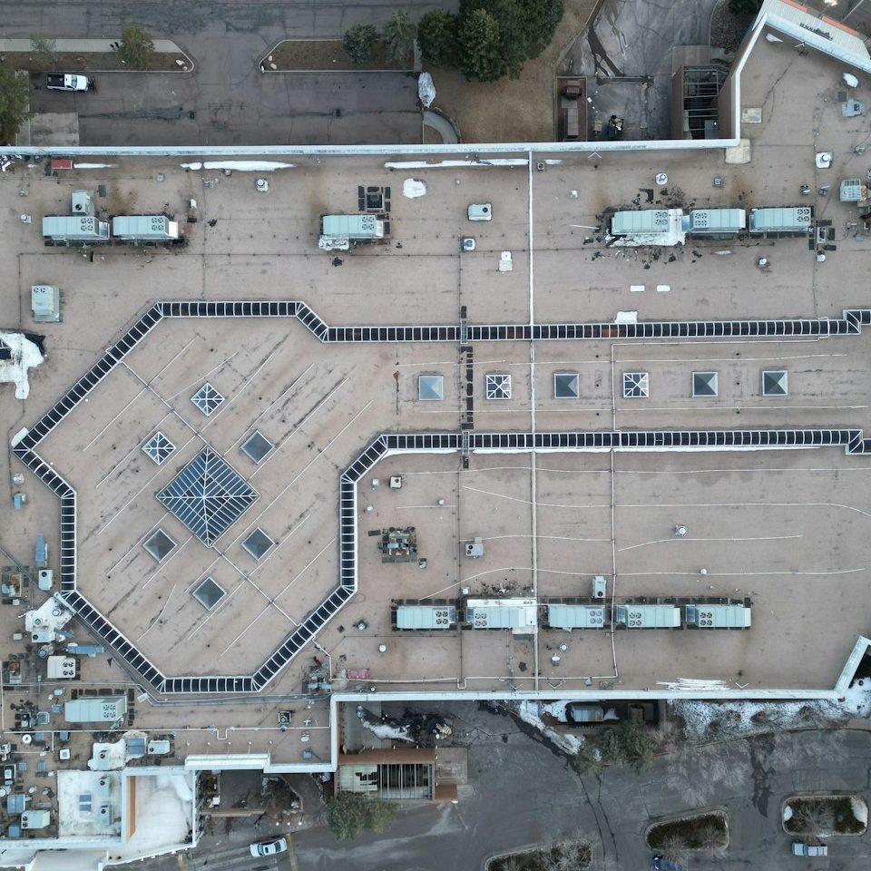Aerial view of a flat rooftop with HVAC units and a central square feature.